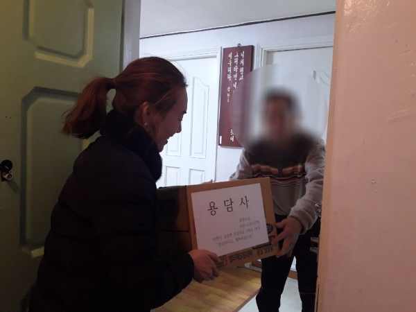용담사에서 기탁한 라면을 어려운 이웃에게 전달하고 있다.