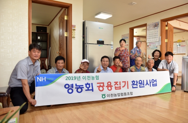 이천농협 이덕배 조합장이 백사면 백우리 마을회관에 냉장고를 지원하고 영농회원들과 기념촬영을 하고 있다.